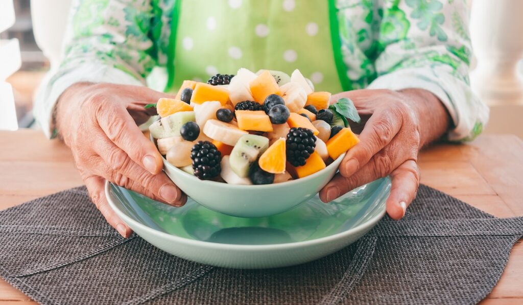 Caucasian mature male hands holding a fresh ready to eat fruit s